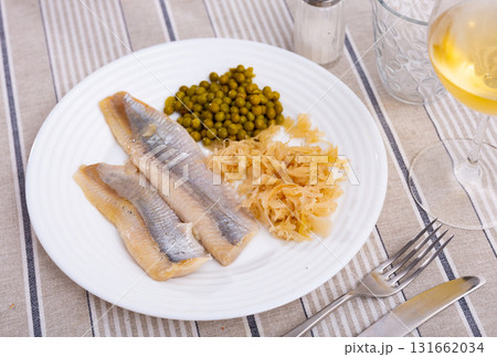 Filets of lightly salted herring with marinated cabbage and pickled peas 131662034