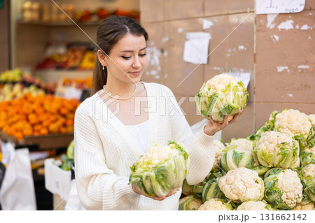 Woman choosing cabbage at the market 131662142