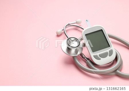 Glucose meter and stethoscope arranged on a pink surface 131662165