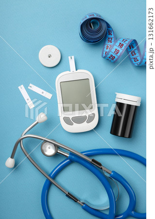 Blood glucose meter and medical tools on blue surface 131662173