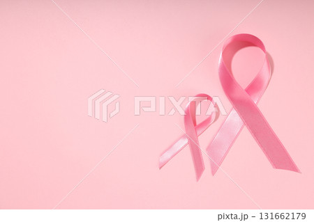 Two pink ribbons positioned on a soft pink background 131662179