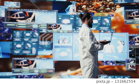 Young medic interacting with virtual health technology for telemedicine, connected systems and smart diagnostics in delivering global healthcare solutions. Biotechnology development. Camera B. Young medic interacting with virtual health technology for telemedicine, connected systems and smart diagnostics in delivering global healthcare solutions. Biotechnology development. Camera B. 131662554