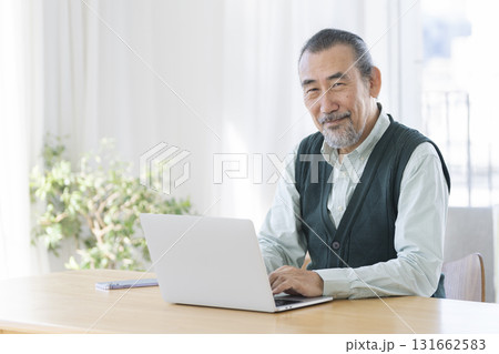 ノートパソコンで作業をするシニア男性 カメラ目線で笑顔のポートレート ノートパソコンで作業をするシニア男性 カメラ目線で笑顔のポートレート 131662583