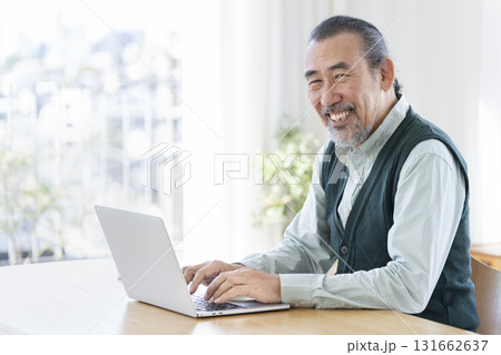 ノートパソコンで作業をするシニア男性　カメラ目線で笑顔のポートレート 131662637