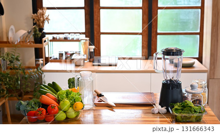 Fresh vegetables and fruits arranged on a wooden kitchen counter with a blender, ready for meal preparation Fresh vegetables and fruits arranged on a wooden kitchen counter with a blender, ready for meal preparation 131666343