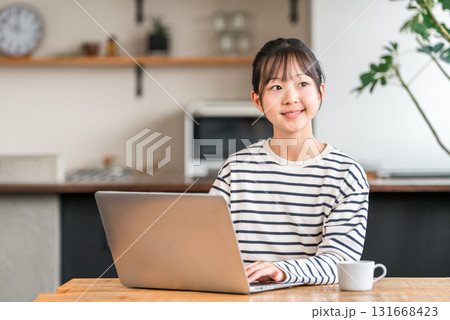 自宅のリビング・スタディコーナーでパソコンを使う小学生・中学生の女の子 131668423