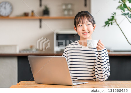 自宅のリビング・スタディコーナーでパソコンを使う小学生・中学生の女の子 自宅のリビング・スタディコーナーでパソコンを使う小学生・中学生の女の子 131668426