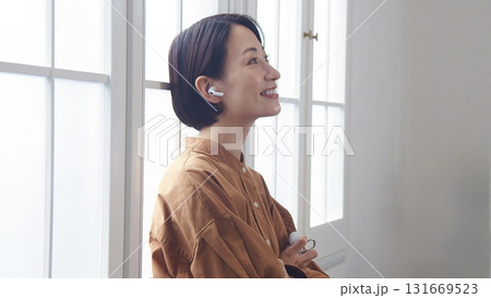 窓際で音楽やラジオを聴いている女性 窓際で音楽やラジオを聴いている女性 131669523