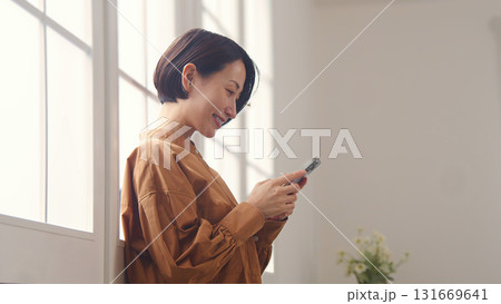 窓際で電話を操作する女性 131669641