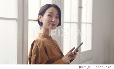 窓際で電話を操作する女性 131669652