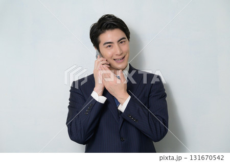 白背景で通話をするスーツの男性 131670542