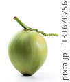A vibrant green young coconut with its stem, photographed vertically and isolated on a clean white background. Tropical fruit and drink. 131670756