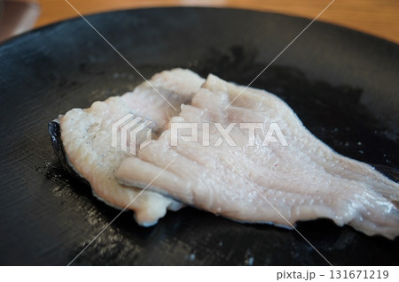 Fresh Raw Eel Fillets on a Black Plate, Ready for Cooking Fresh Raw Eel Fillets on a Black Plate, Ready for Cooking 131671219