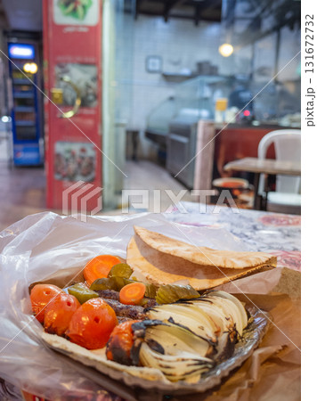 【ヨルダン】首都アンマンのレストランでテイクアウトした焼きトマトや玉ねぎが添えられたケバブプレート 131672732