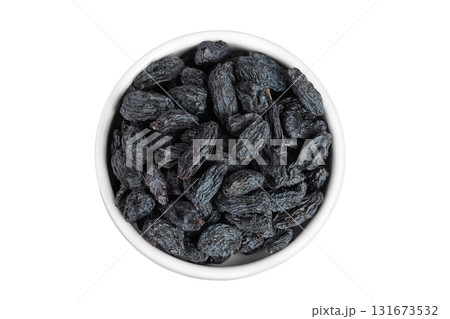 black raisins in ceramic bowl isolated on white background. Top view. Flat lay 131673532