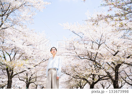 桜を見上げる若い女性　ライフスタイルイメージ 131673998