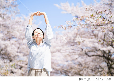 桜の木の下でストレッチをする若い女性　ライフスタイルイメージ 131674006