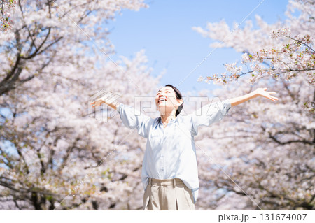 桜の木の下でストレッチをする若い女性　ライフスタイルイメージ 131674007