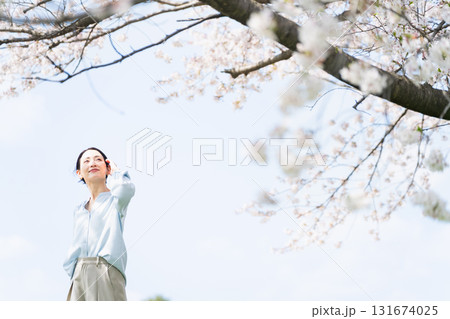 桜の木を見上げる若い女性　ライフスタイルイメージ 131674025
