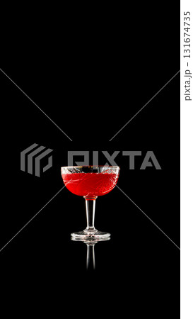 Red cocktail in crystal glass on reflective black background Red cocktail in crystal glass on reflective black background 131674735