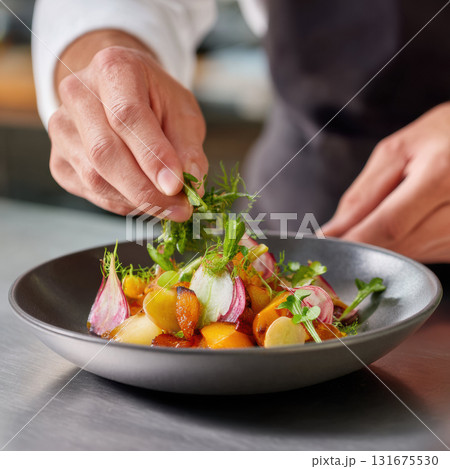 Professional chef plating sophisticated gourmet dish with fresh vegetable in restaurant kitchen. close up shows meticulous preparation and culinary art Professional chef plating sophisticated gourmet dish with fresh vegetable in restaurant kitchen. close up shows meticulous preparation and culinary art 131675530