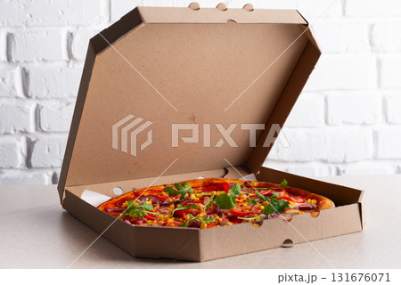 Large Pizza in open carton box on kitchen table closeup view Large Pizza in open carton box on kitchen table closeup view 131676071