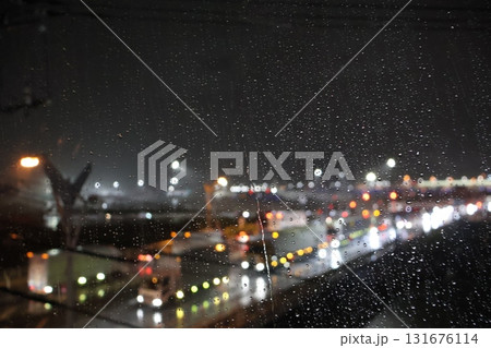 窓に雨粒がつきキラキラ光る夜景が見える風景 131676114