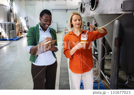 Brewery women performing quality control during beer production 131677023