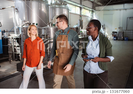 People walking and talking in brewery production facility 131677060