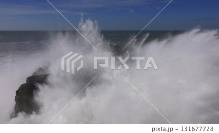 High waves breaking on the rocks of the coastline 131677728