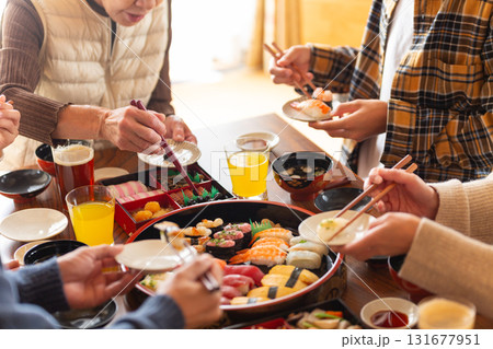 実家へ帰省した家族とおばあちゃんで囲む正月の食卓 131677951