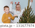 Christmas, house and hug with mother, son and bonding together with gift, decoration and care in lounge. Xmas tree, family and parent with boy, embrace and present with happiness, holiday and festive 131677974