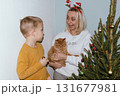 Christmas, house and hug with mother, son and bonding together with gift, decoration and care in lounge. Xmas tree, family and parent with boy, embrace and present with happiness, holiday and festive 131677981
