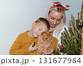 Christmas, house and hug with mother, son and bonding together with gift, decoration and care in lounge. Xmas tree, family and parent with boy, embrace and present with happiness, holiday and festive 131677984