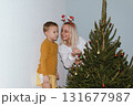 Christmas, house and hug with mother, son and bonding together with gift, decoration and care in lounge. Xmas tree, family and parent with boy, embrace and present with happiness, holiday and festive 131677987