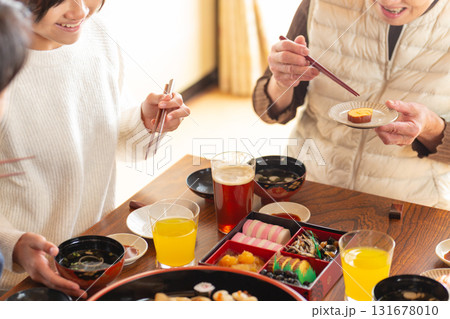 実家へ帰省した家族とおばあちゃんで囲む正月の食卓 131678010