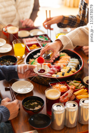 実家へ帰省した家族とおばあちゃんで囲む正月の食卓 131678079