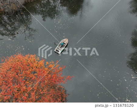 Person rowing boat on lake among autumn trees, Kazakhstan 131678120