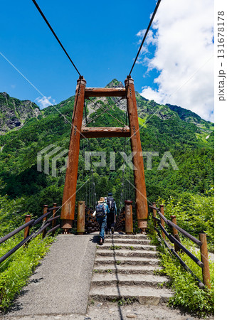 上高地・明神橋を渡る登山者と明神岳 夏の爽やかな山岳風景 上高地・明神橋を渡る登山者と明神岳 夏の爽やかな山岳風景 131678178