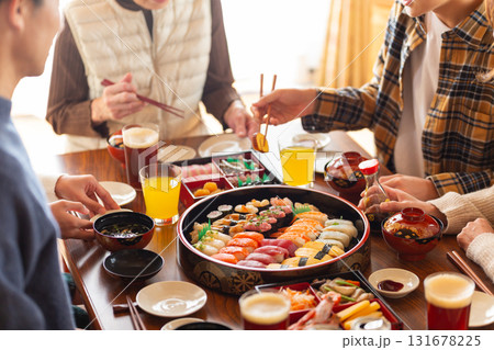 実家へ帰省した家族とおばあちゃんで囲む正月の食卓 131678225