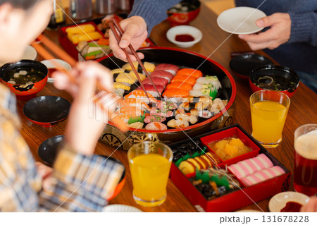 実家へ帰省した家族とおばあちゃんで囲む正月の食卓 131678228