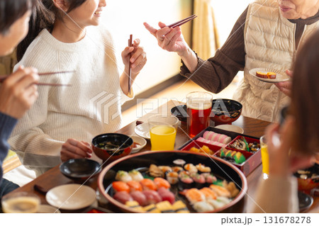 実家へ帰省した家族とおばあちゃんで囲む正月の食卓 131678278