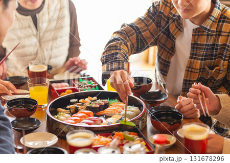 実家へ帰省した家族とおばあちゃんで囲む正月の食卓 131678296