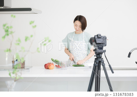 料理の様子を撮影するYoutuberの主婦のような女性 131678383