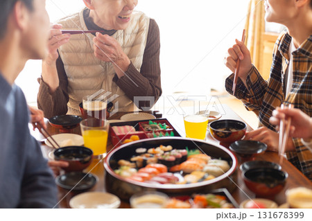 実家へ帰省した家族とおばあちゃんで囲む正月の食卓 131678399