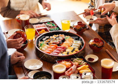 実家へ帰省した家族とおばあちゃんで囲む正月の食卓 131678574