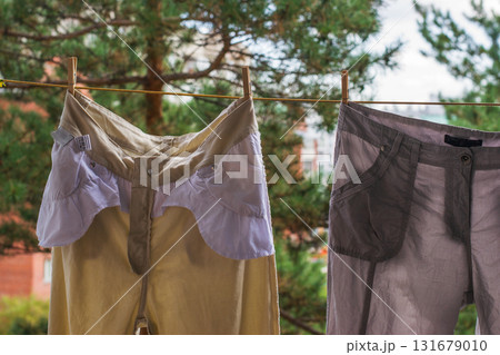 Trousers are dried after washing on a rope on a sunny day. Blurred background The concept of washing and cleaning. 131679010