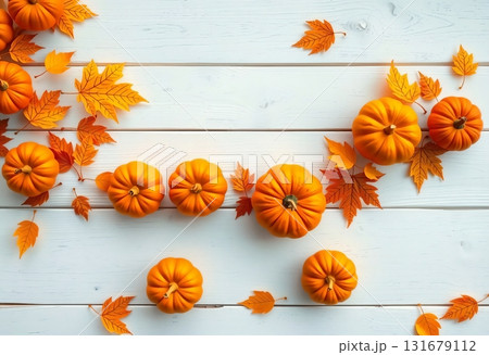 Bright pumpkins and autumn leaves on white wood background 131679112