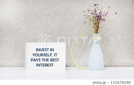 The inscription Invest in yourself, it pays the best interest, appears on a white notebook. 131679290