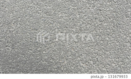 Surface texture of a gray concrete pavement displaying fine details and patterns under natural light 131679933
